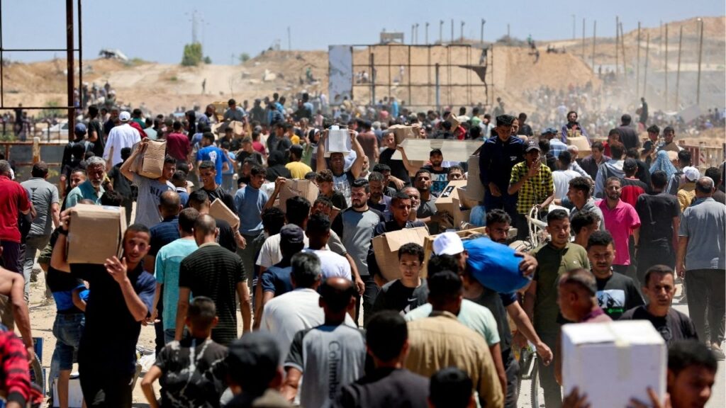 Palestinians carry aid supplies which they received from the U.S.-backed Gaza Humanitarian Foundation, in the central Gaza Strip, May 29, 2025. (Reuters File)