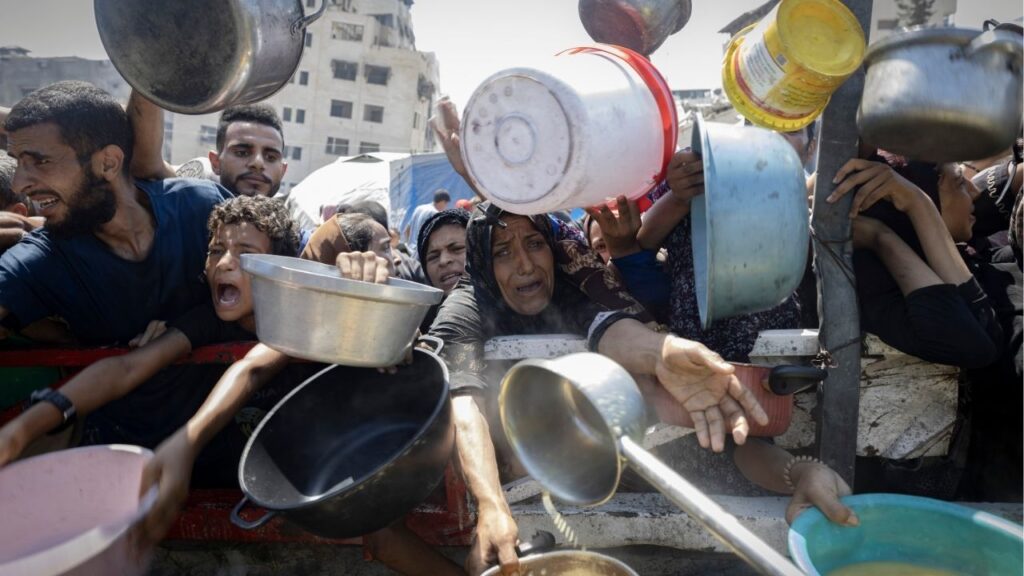 Displaced Palestinians wait in front of a charity kitchen in the western Gaza City area, July 23, 2025. Two government officials said Britain was actively weighing the recognition of a Palestinian state, in a shift driven by public pressure over starvation in Gaza. (Saher Alghorra/The New York Times)