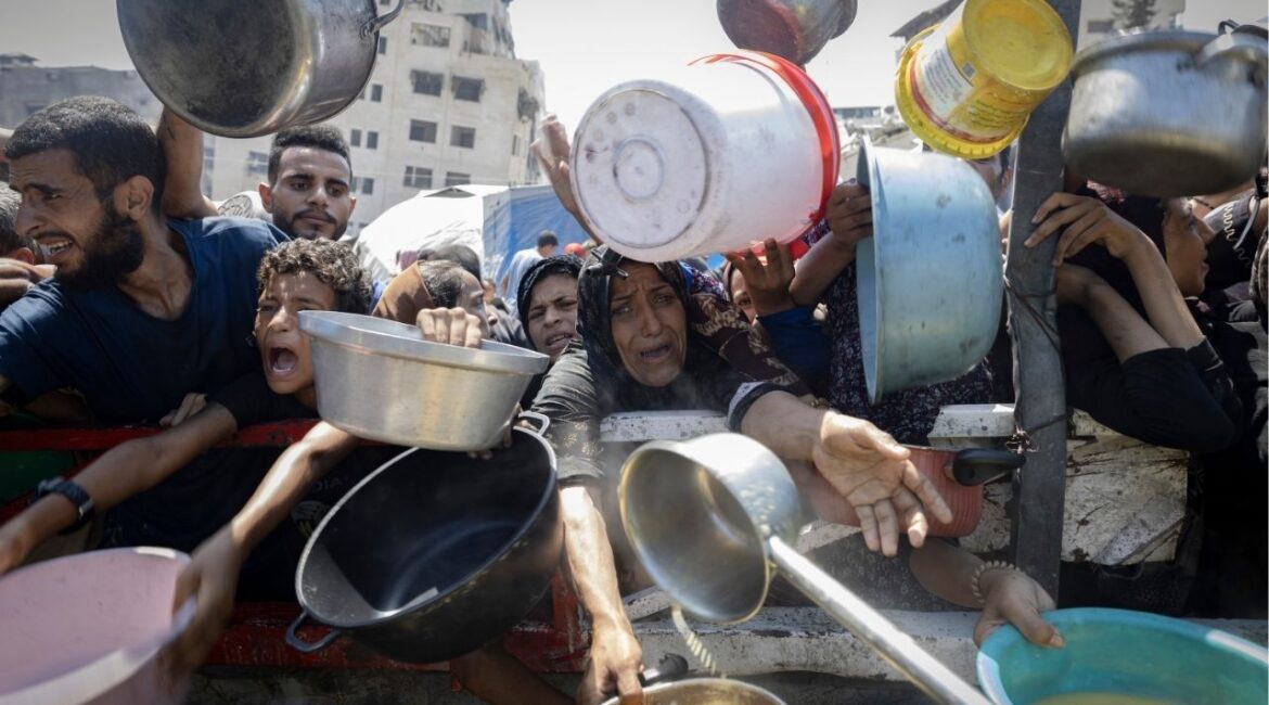 Displaced Palestinians wait in front of a charity kitchen in the western Gaza City area, July 23, 2025. Two government officials said Britain was actively weighing the recognition of a Palestinian state, in a shift driven by public pressure over starvation in Gaza. (Saher Alghorra/The New York Times)