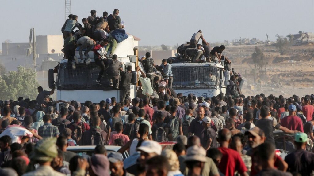 Palestinians climb onto trucks as they seek aid supplies in Khan Younis, southern Gaza Strip, August 4, 2025. REUTERS/Hatem Khaled