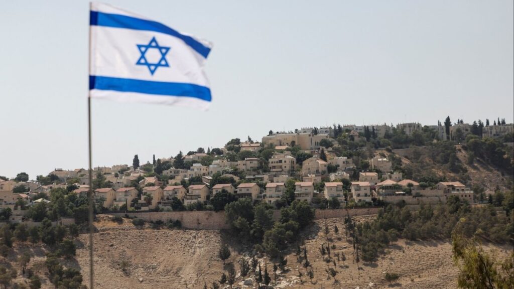 An Israeli flag flutters, as part of the Israeli settlement of Maale Adumim is visible in the background, in the Israeli-occupied West Bank, August 14, 2025. (Reuters/Ronen Zvulun)