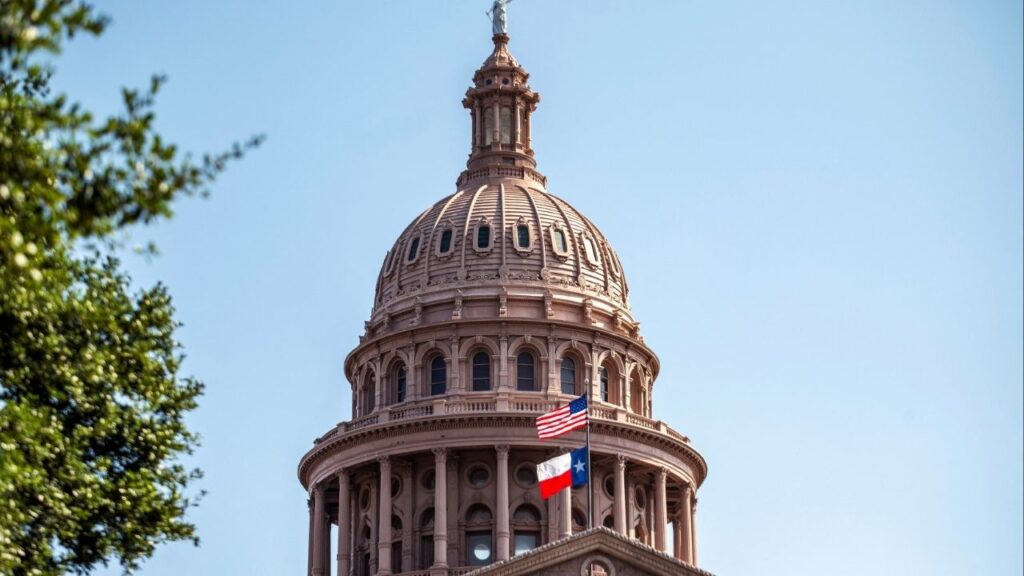The U.S. and Texas state flags flutter on the day of a special session of the Texas House after Democratic lawmakers left the state to deny Republicans the opportunity to redraw the state's 38 congressional districts, in Austin, Texas, U.S., August 14, 2025. (Reuters/Sergio Flores)