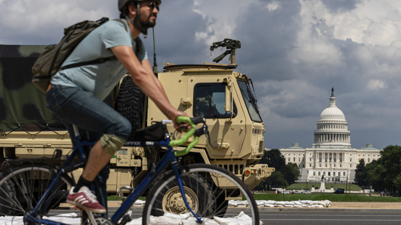 Cyclist Passes National Guard Vehicle on the National Mall
