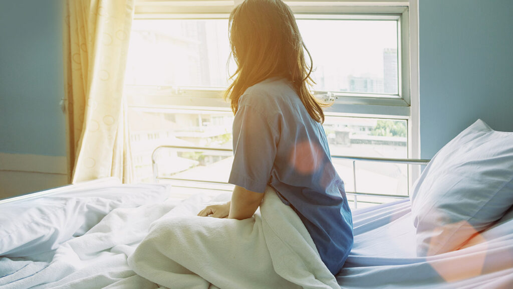 woman looking outside of a hospital
