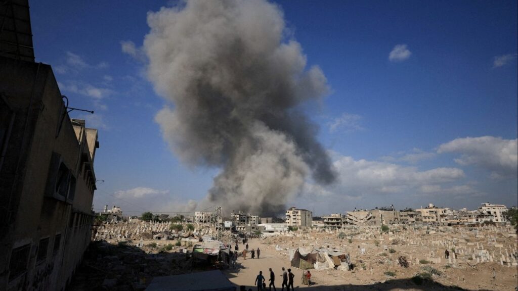 Palestinians gather near a cemetery as smoke rises following an explosion during an Israeli operation in Gaza City, August 28, 2025. (Reuters File)